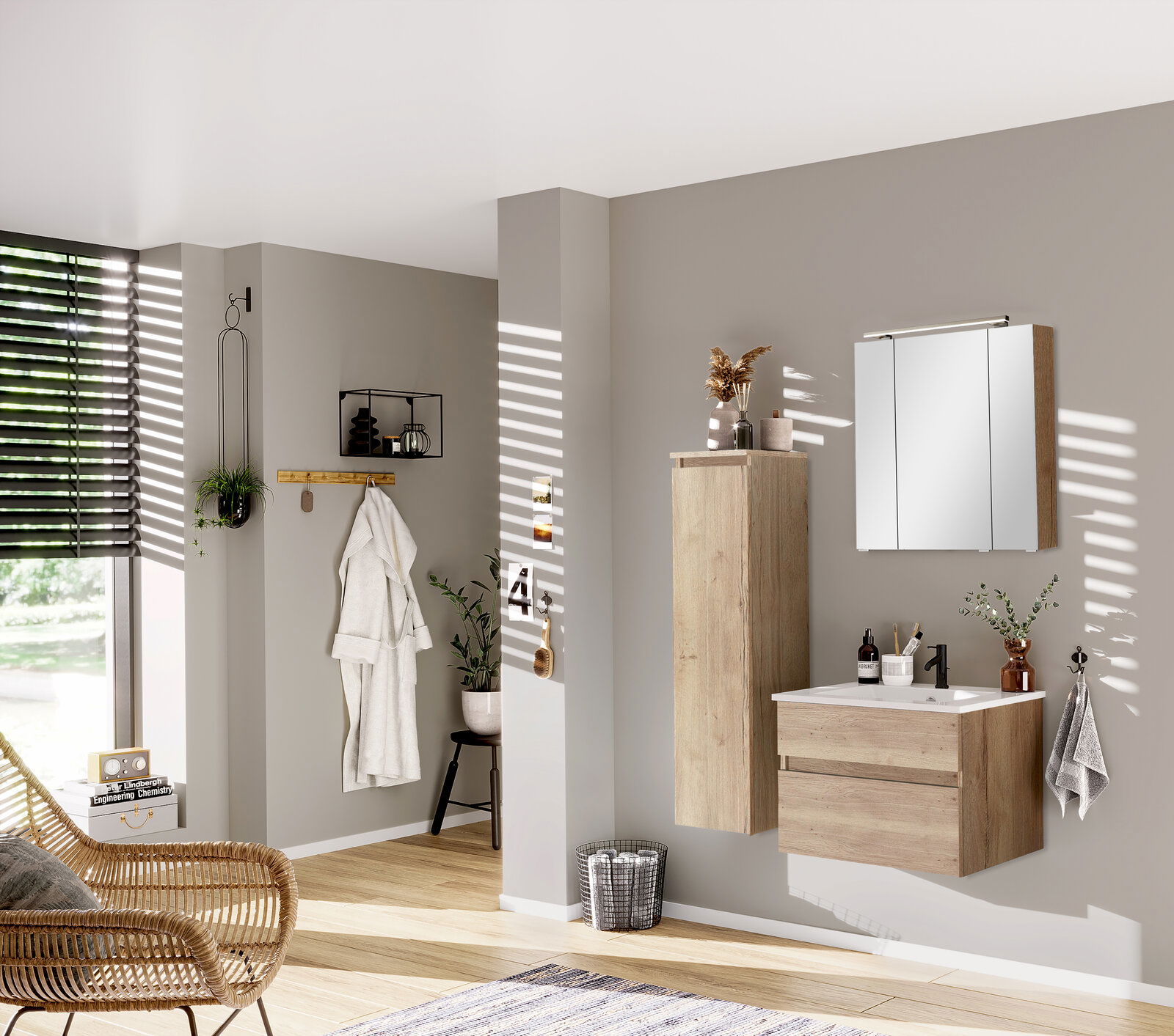 Novel Mittelschrank links NV.210 Moderner Badezimmer-Mittelschrank in Holzoptik, links an der Wand montiert, mit dekorativen Elementen und Spiegel im Hintergrund, seitliche Perspektive.