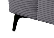 Nahaufnahme eines grauen Funktionssofas mit geripptem Stoffbezug und schwarzem Metallfuß, seitliche Perspektive