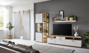 Moderne Wohnzimmer-Wandkombination mit Holz- und Weißakzenten, bestehend aus einem TV-Schrank, einem Regal mit Glasvitrine und einem Wandregal, seitliche Perspektive.