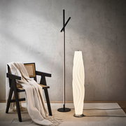 Moderne LED-Stehleuchte in einem stilvollen Wohnzimmer, seitliche Perspektive.