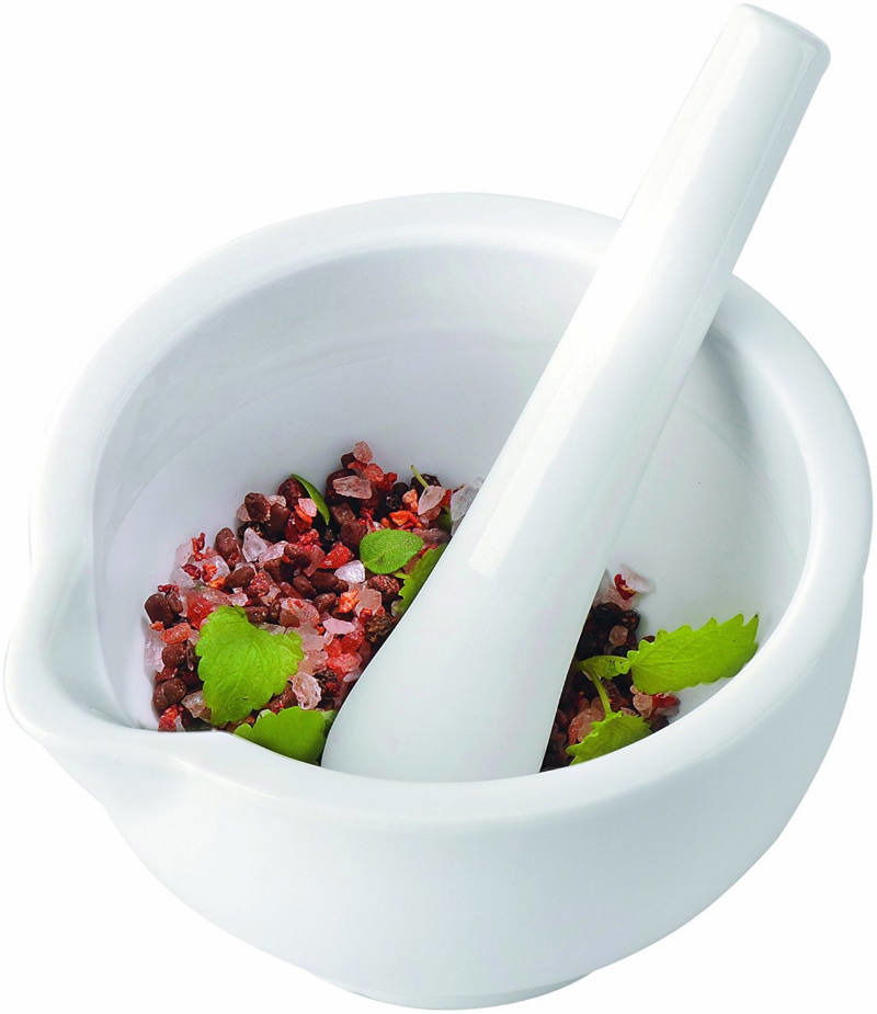 Weißer Mörser mit Stößel, gefüllt mit grobem Salz und Kräutern, aus der Vogelperspektive.