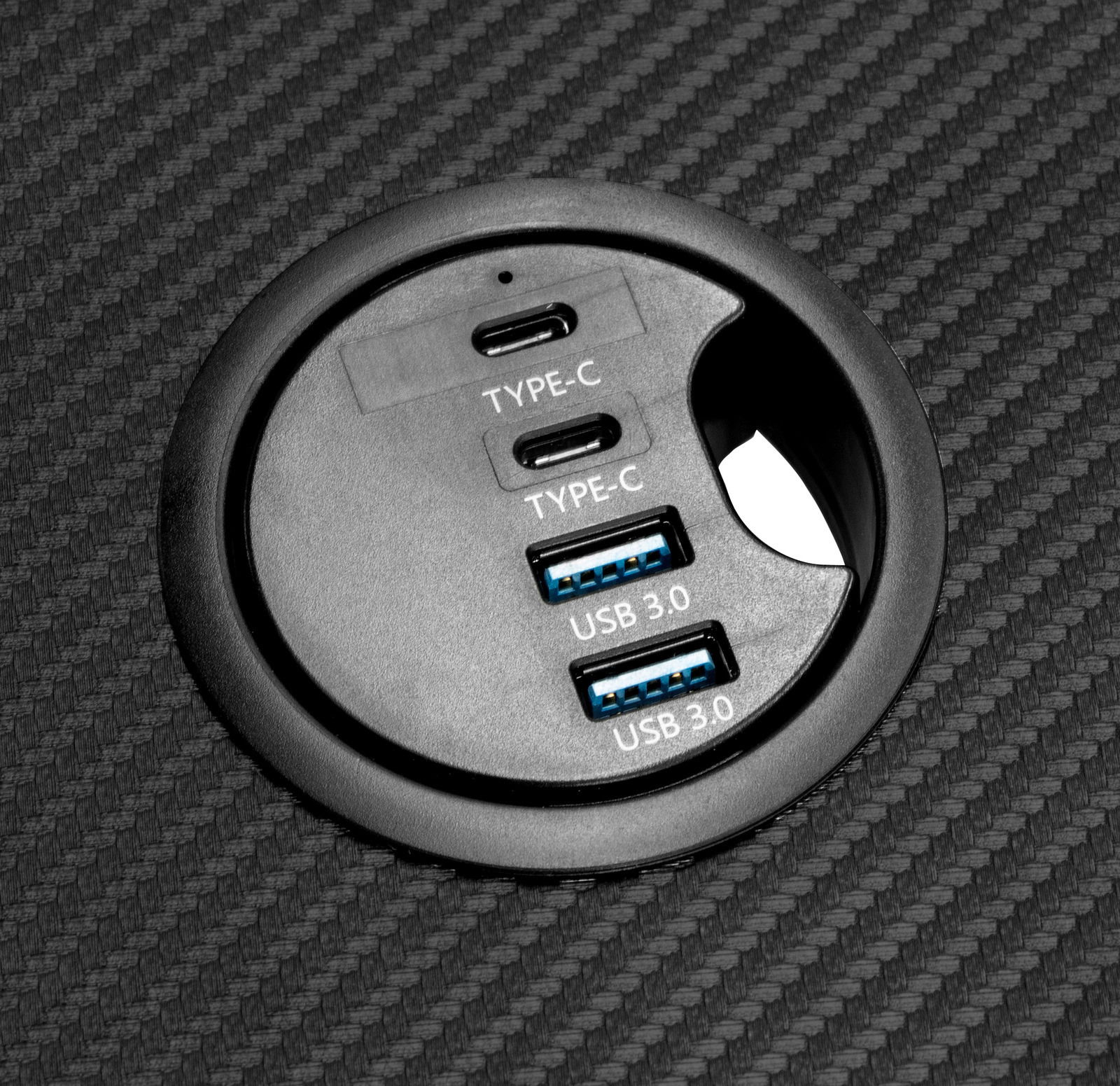 Nahaufnahme eines runden Anschlussfelds auf einem Gaming Tisch mit zwei USB 3.0- und zwei Typ-C-Anschlüssen.