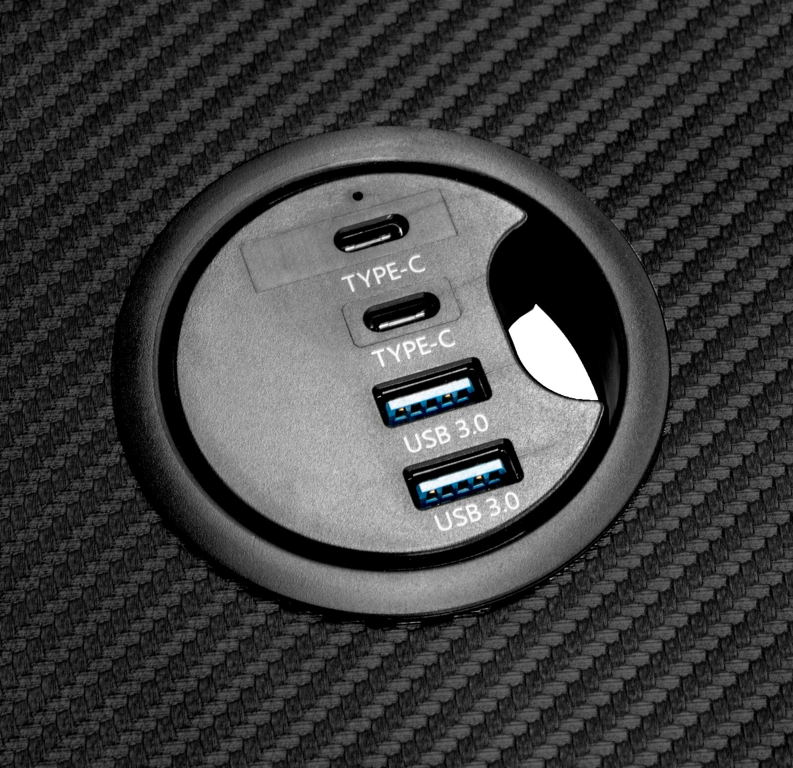 Close-up van een rond aansluitpaneel op een gamingtafel met twee USB 3.0- en twee Type-C-aansluitingen.
