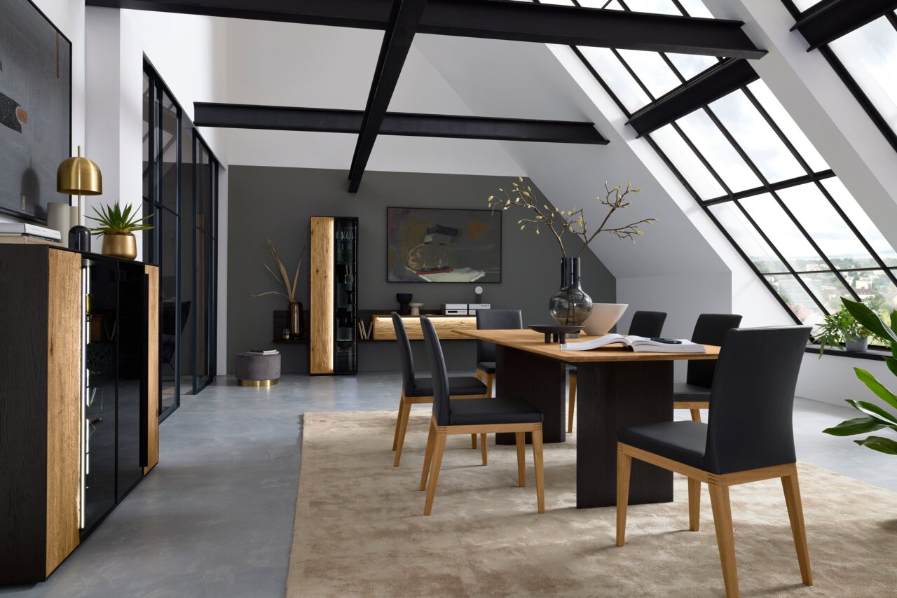Max Berger Eettafel GARDA Moderne woonkamerinrichting met eettafel en stoelen in een lichte ruimte met grote ramen, zijaanzicht.