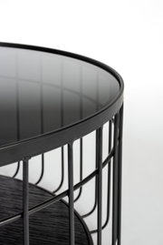Nahaufnahme eines modernen Couchtisches mit schwarzer Glasplatte und Metallgestell, seitliche Perspektive.
