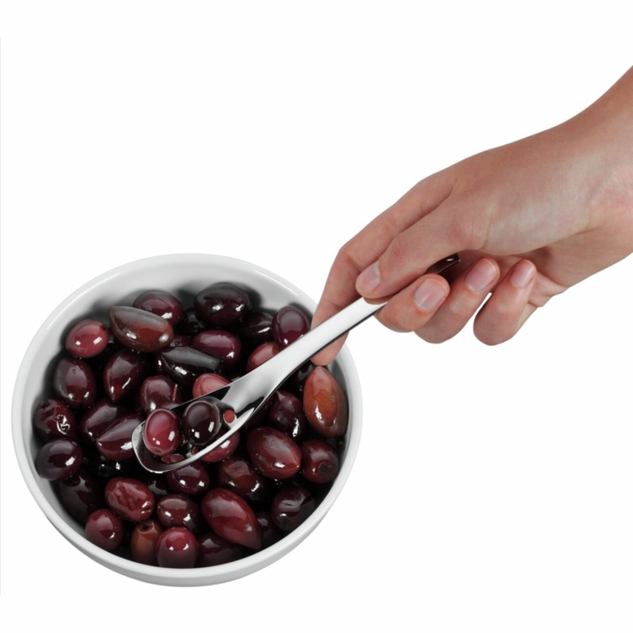 Hand hält einen Servierlöffel Nuova 16cm über einer Schale mit Oliven, seitliche Perspektive