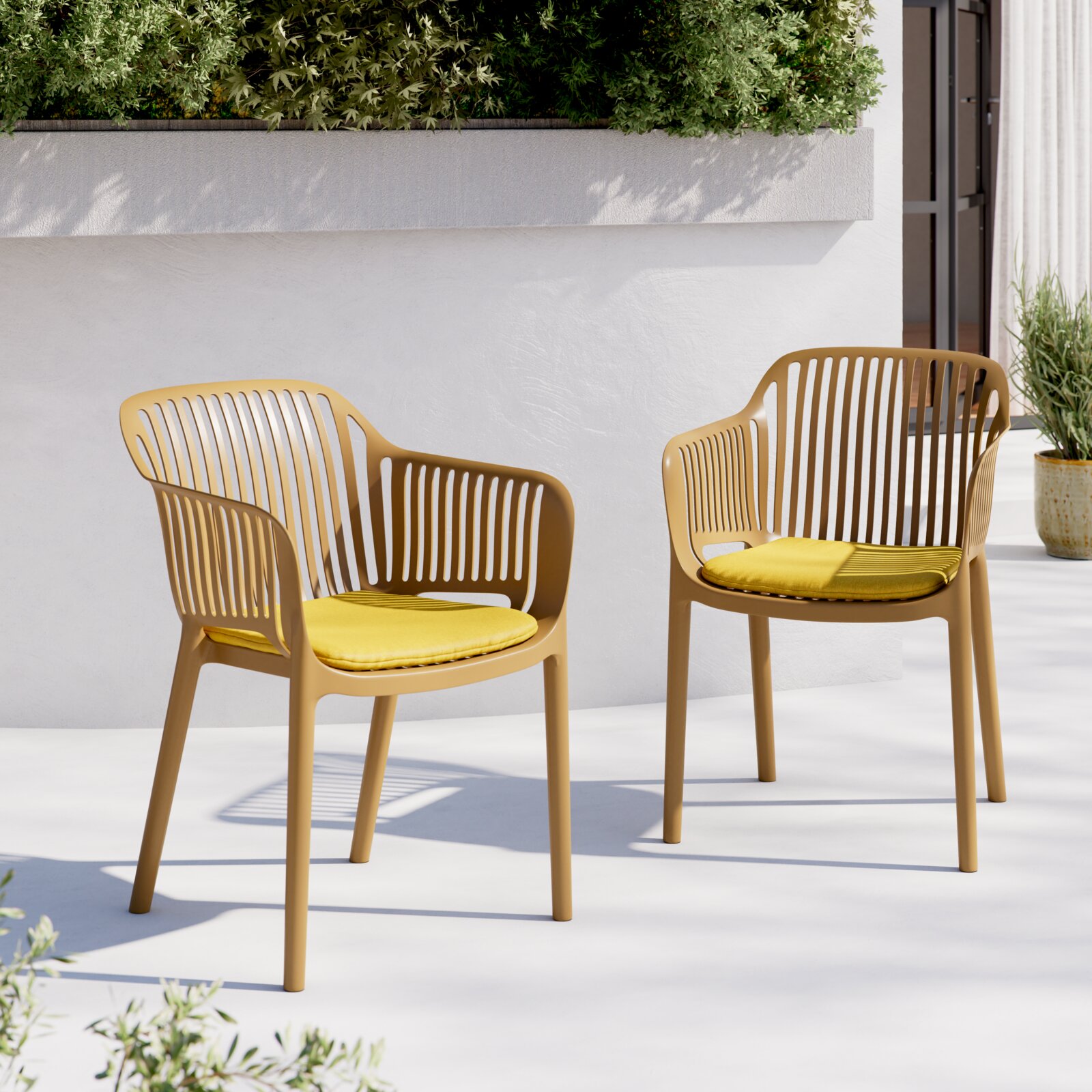 Zwei moderne Outdoor-Stühle aus beigefarbenem Kunststoff mit schlitzförmiger Rückenlehne und gelben Sitzkissen auf heller Terrasse vor weißer Wand und Pflanzen, perspektivisch in leichter Seitenansicht