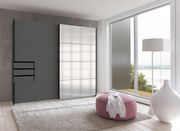 Moderner Schwebetürenschrank mit zwei Türen, links in dunklem Grau und rechts mit spiegelnder Oberfläche, in einem hellen Raum mit Blick auf eine Terrasse.