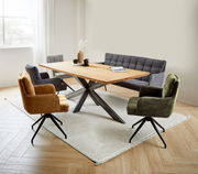 Moderner Essbereich mit einem großen Holztisch und verschiedenen Armlehnstühlen in unterschiedlichen Farben, aus der Perspektive von schräg oben fotografiert.