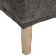 Nahaufnahme eines Hockers mit grauem Stoffbezug und hellem Holzbein, Perspektive von unten.