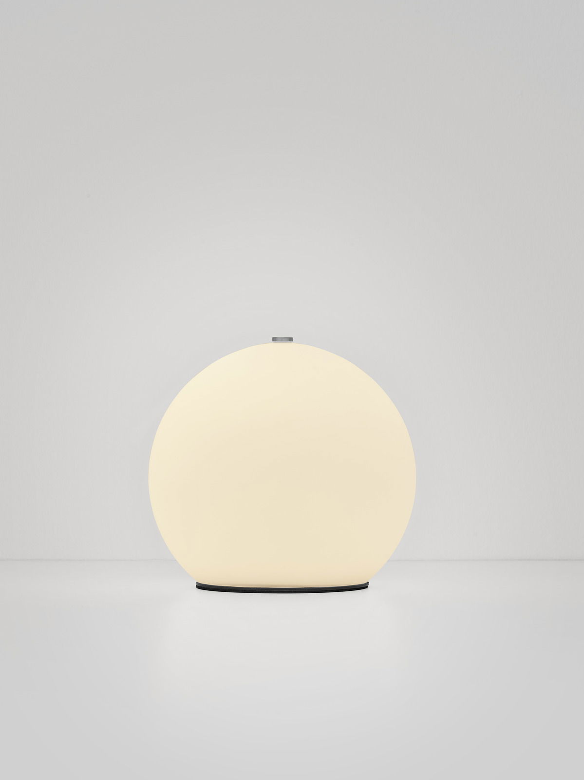 Runde Akku-Tischleuchte in sanftem Licht, frontal betrachtet.