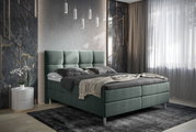 Boxbett in modernem Schlafzimmer, seitliche Perspektive, mit grauem Polsterkopfteil und eleganter Beleuchtung.