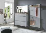 Modernes Garderoben-Set in Grau mit Holzablage, bestehend aus Kommode mit Spiegel und Wandpaneel mit Haken und Ablage, in einem hellen Flur – Frontansicht in leichter Schrägperspektive von links.