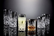 Sechs elegante Kristallgläser der Noblesse-Serie, darunter Whisky- und Longdrinkbecher, auf einer glänzenden Oberfläche mit seitlicher Perspektive.