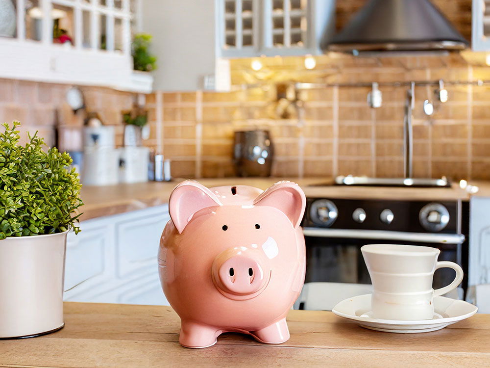 Rosa Sparschwein auf einem Holztisch in einer Küche. 