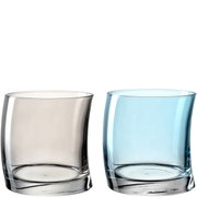 Zwei Becher aus Glas, einer in klarem und einer in hellblauem Glas, frontal nebeneinander stehend.
