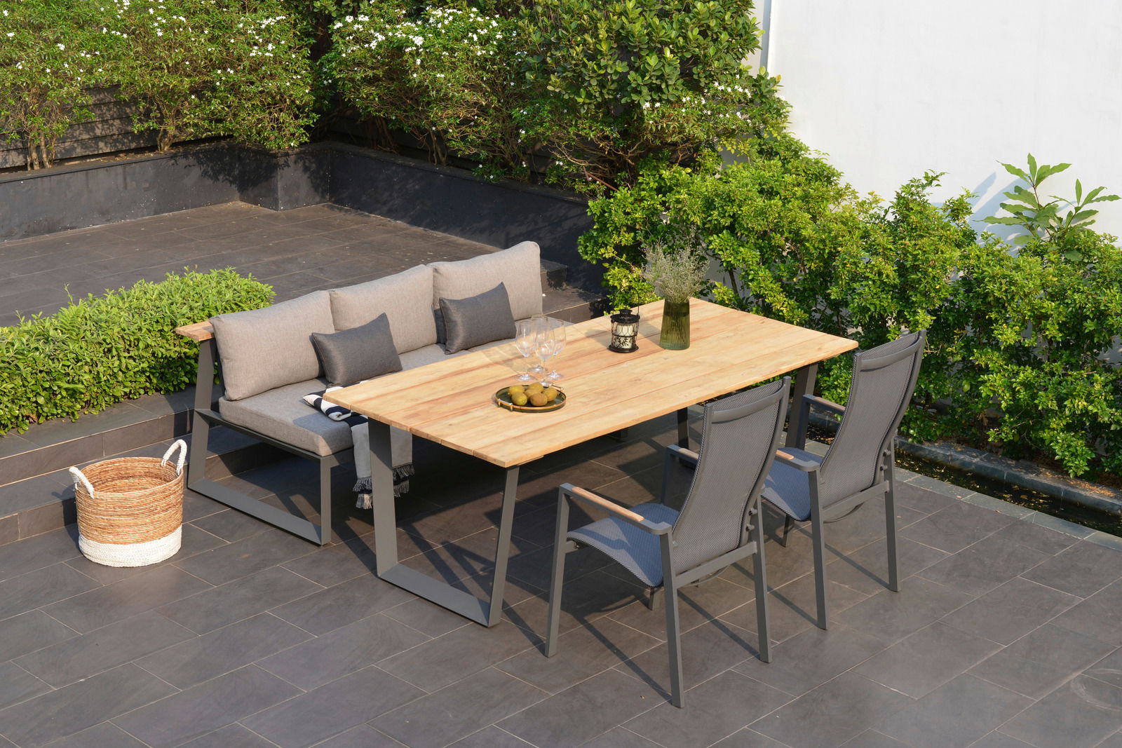 Gartenmöbel-Set mit Sitzbank und Tisch aus Holz, umgeben von grünen Pflanzen, aus der Vogelperspektive fotografiert.