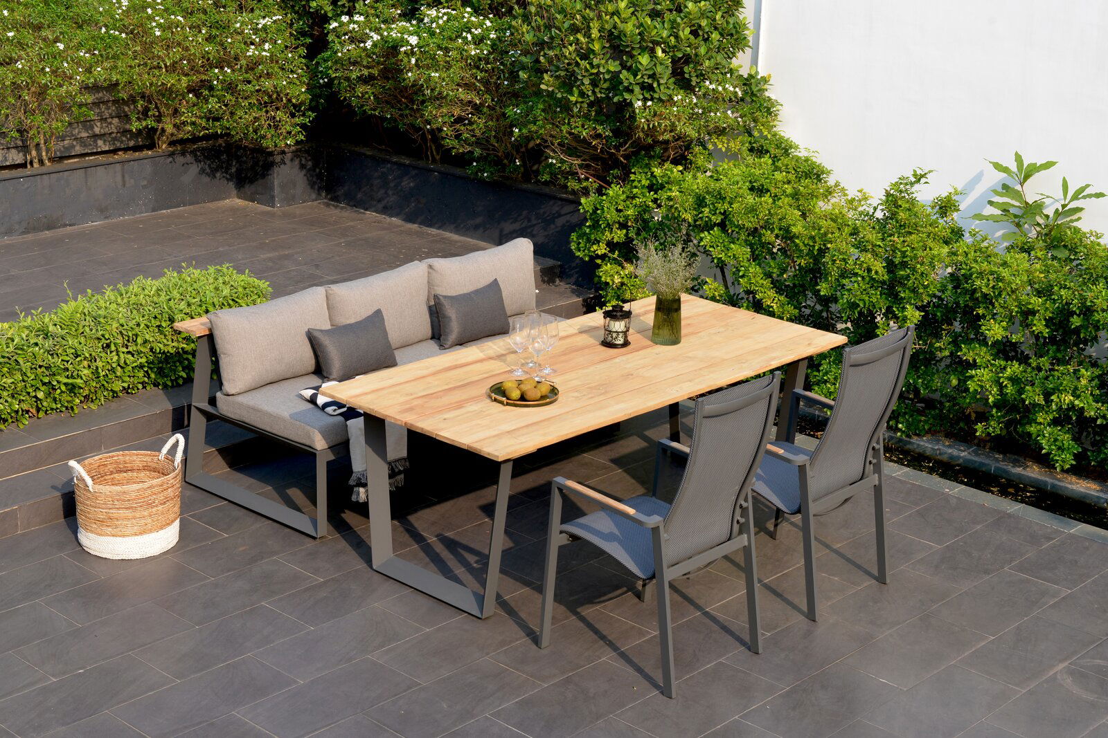 Gartenmöbel-Set mit Sitzbank und Tisch aus Holz, umgeben von grünen Pflanzen, aus der Vogelperspektive fotografiert.