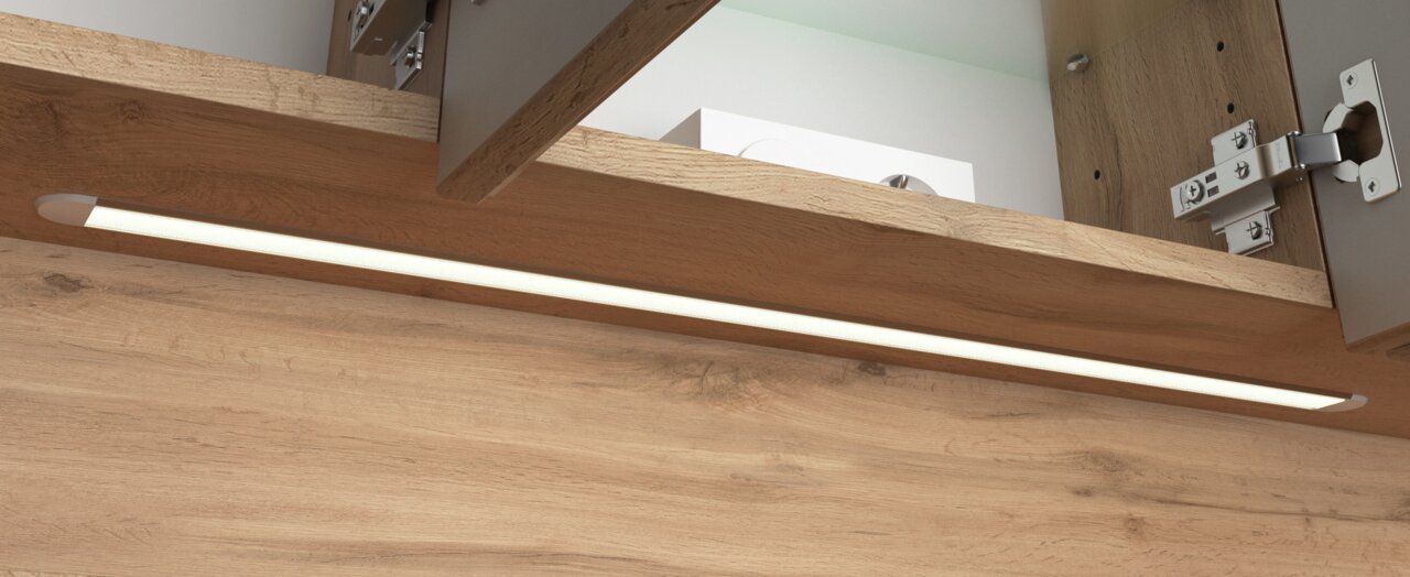 Nahaufnahme eines Spiegelschranks mit Holzoptik und integrierter LED-Beleuchtung von unten betrachtet.