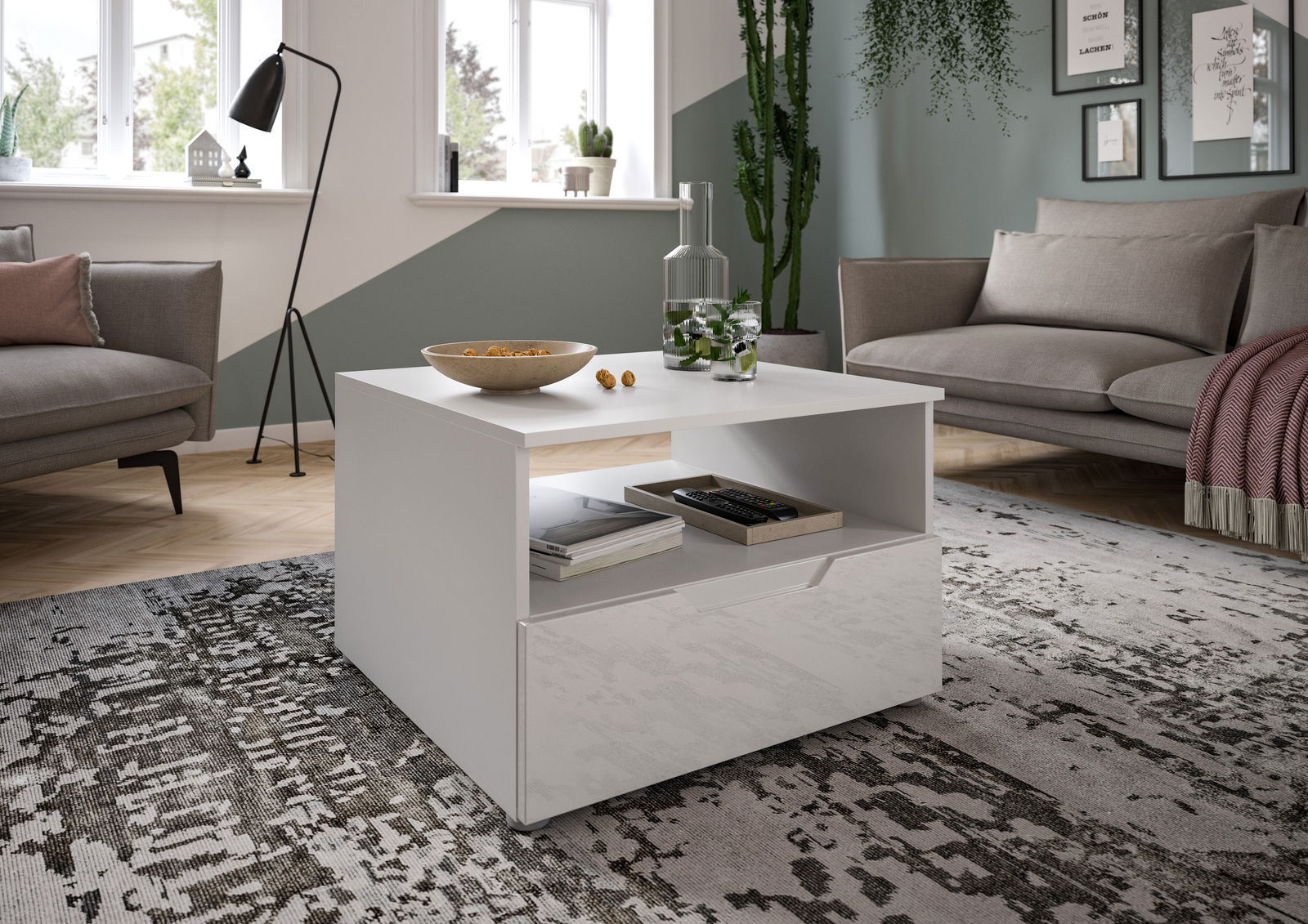 MID.YOU Couchtisch HILTON Moderner weißer Couchtisch mit Stauraum, dekoriert mit einer Schale und einer Karaffe, in einem stilvoll eingerichteten Wohnzimmer. Perspektive von vorne links.