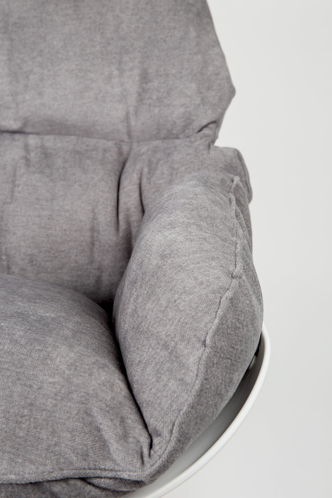 Nahaufnahme eines grauen Schaukelsessels mit weicher Polsterung, seitliche Perspektive.