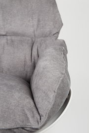 Nahaufnahme eines grauen Schaukelsessels mit weicher Polsterung, seitliche Perspektive.