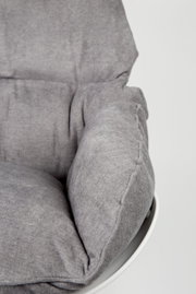 Close-up van een grijze schommelstoel met zachte bekleding, gezien vanaf de zijkant.