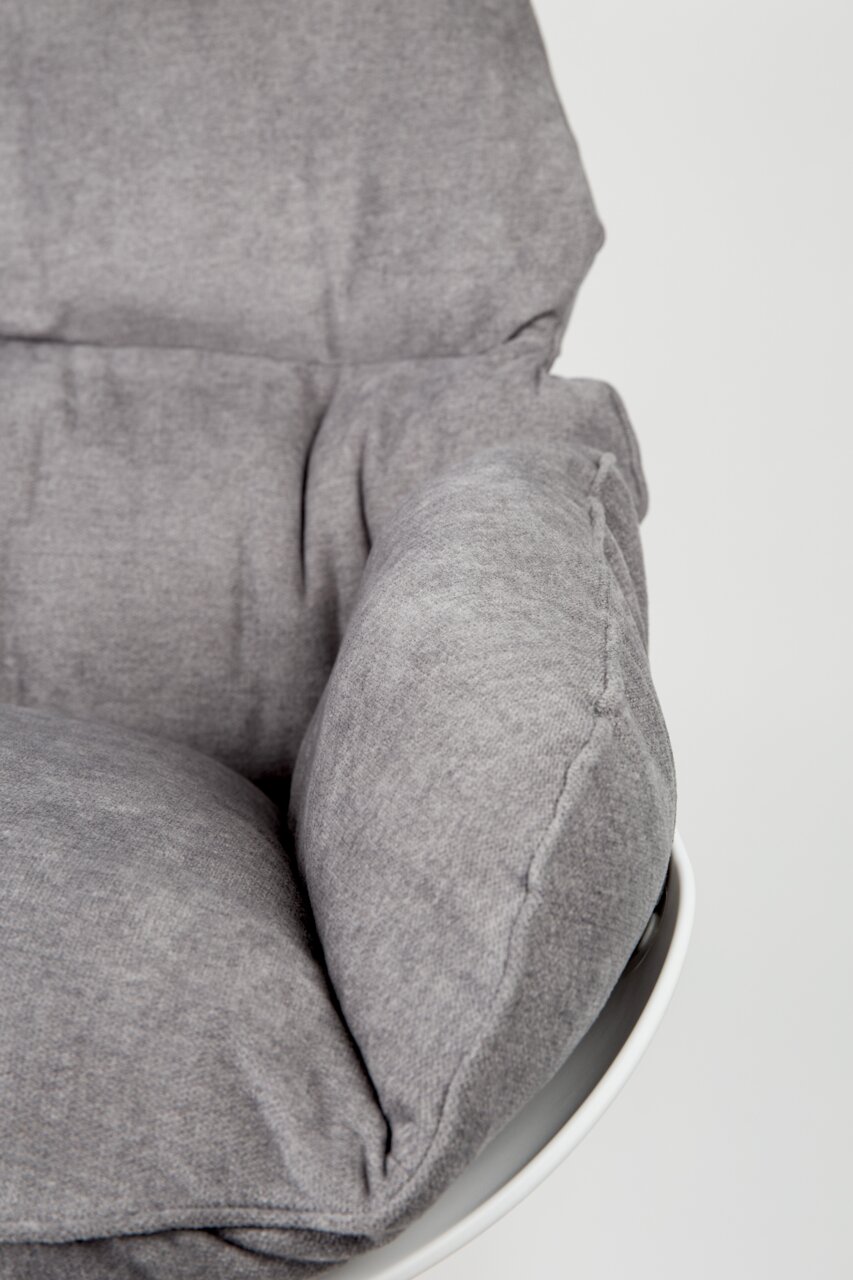 Close-up van een grijze schommelstoel met zachte bekleding, gezien vanaf de zijkant.