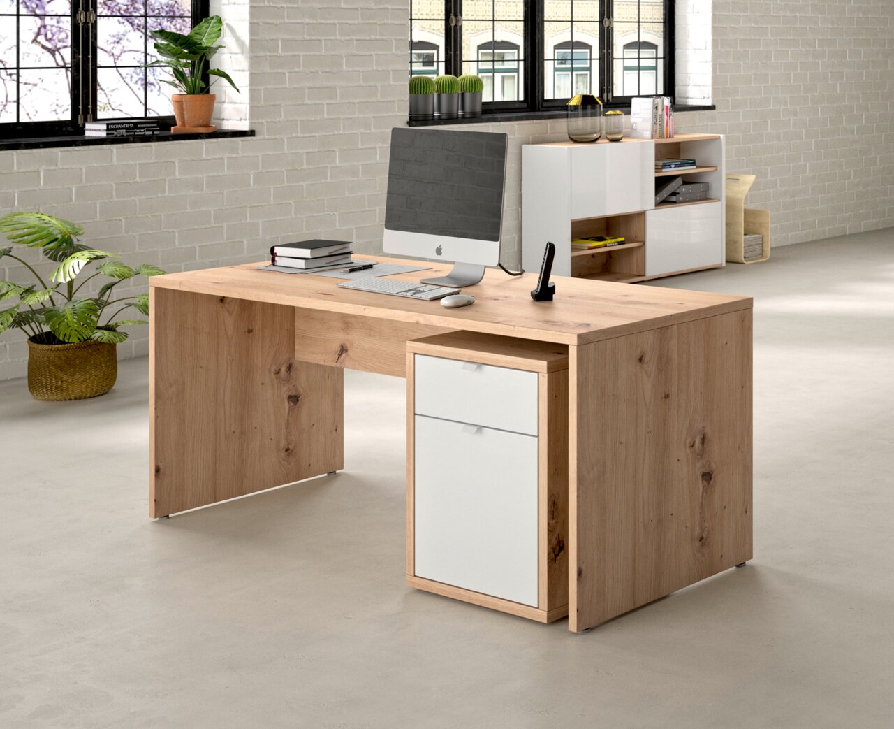 Modern houten bureau met ingebouwde ladekast, zijaanzicht, in een kantoor met planten en een computer.