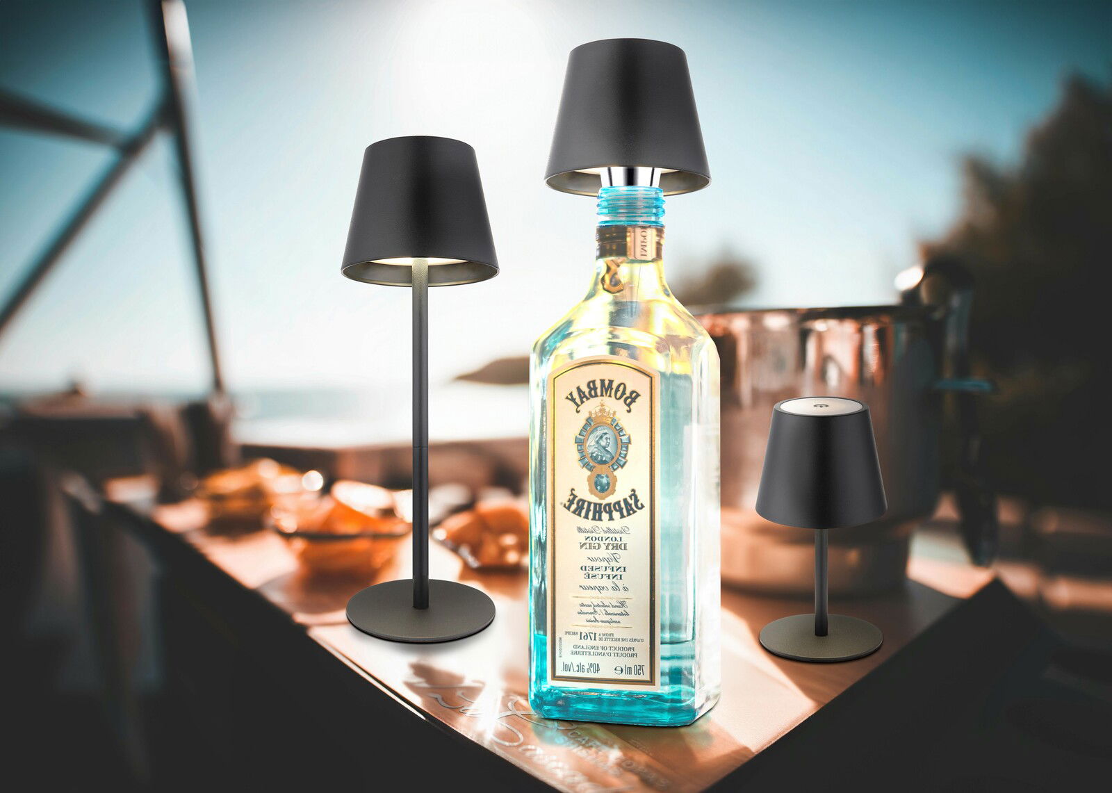 Akku-Tischleuchte VANNIE 3 in stilvollem Design, präsentiert in einer sommerlichen Outdoor-Umgebung mit direkter Frontalansicht.