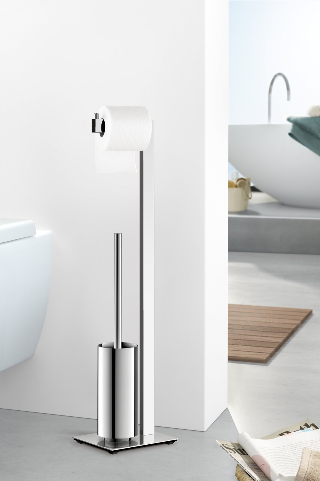 Vrijstaand toiletmeubel van gepolijst roestvrij staal met toiletrolhouder en geïntegreerde toiletborstel op een vierkante voetplaat, zijaanzicht in de badkamer naast het toilet