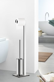 Freistehende WC-Garnitur aus poliertem Edelstahl mit Toilettenpapierhalter und integrierter Toilettenbürste auf quadratischer Bodenplatte, seitliche Frontansicht im Badezimmer neben dem WC