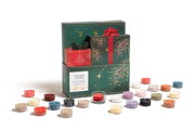 Yankee Candle adventskalender in donkergroene geschenkverpakking met feestelijk vuurwerkdesign, omringd door 24 kleurrijke geurkaarsjes, schuin van voren gezien