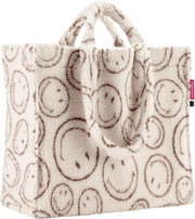 Flauschige Reisenthel Shopper-Tasche aus Teddyfleece in Cremeweiß mit braunem Smileymuster und zwei Henkeln, Frontansicht leicht von oben auf weißem Hintergrund