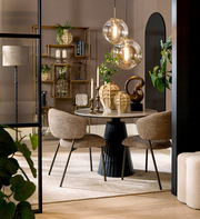 Eleganter Essbereich mit rundem Tisch und zwei gepolsterten Stühlen, dekoriert mit modernen Vasen und hängenden Glaskugelleuchten, seitliche Perspektive.