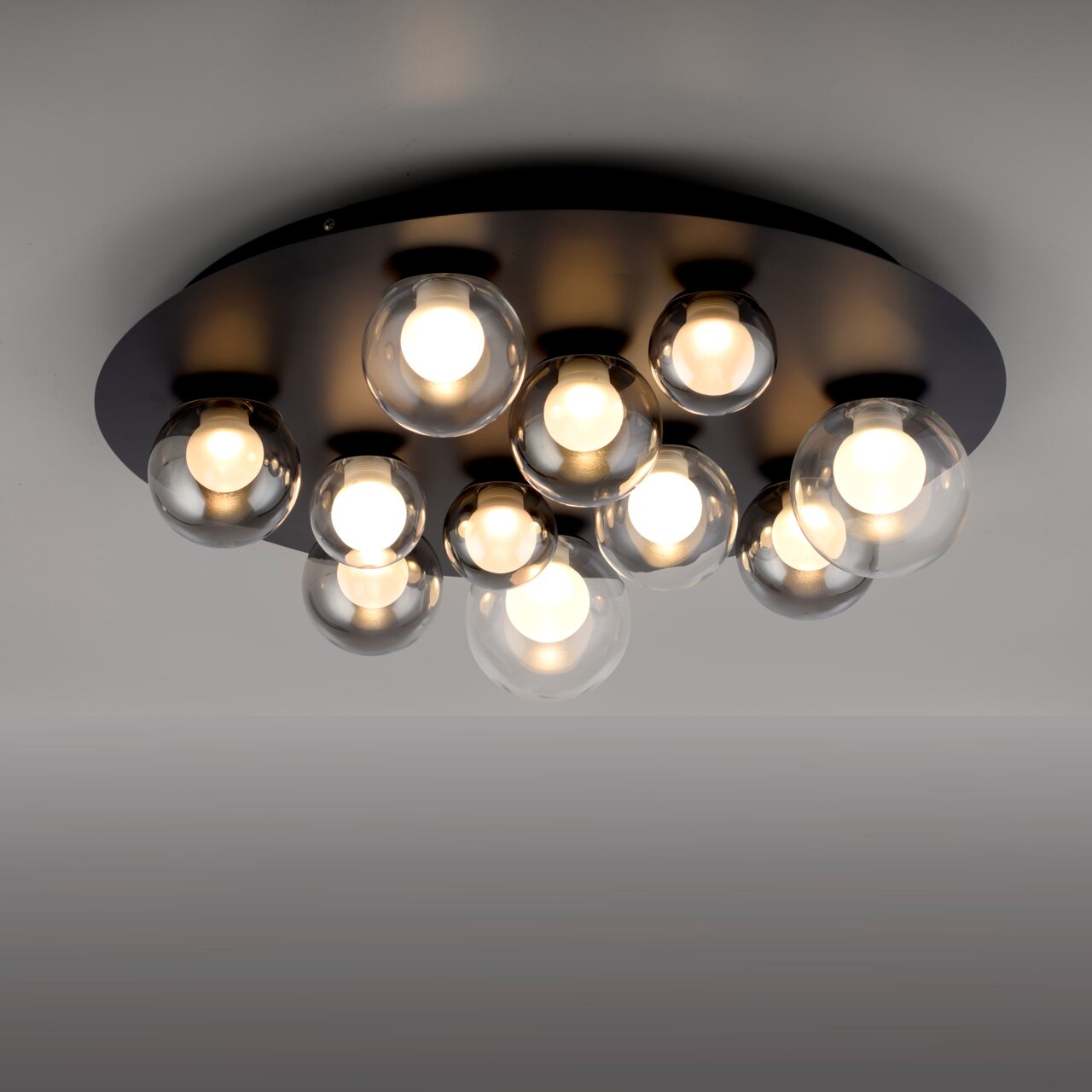 Moderne led-plafondlamp met meerdere bolvormige glazen elementen, gezien van onderaf.