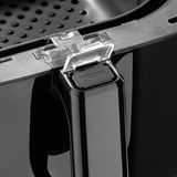 Nahaufnahme eines Griffs einer Heißluftfritteuse mit einem Druckknopf und einem transparenten Verschlussmechanismus.