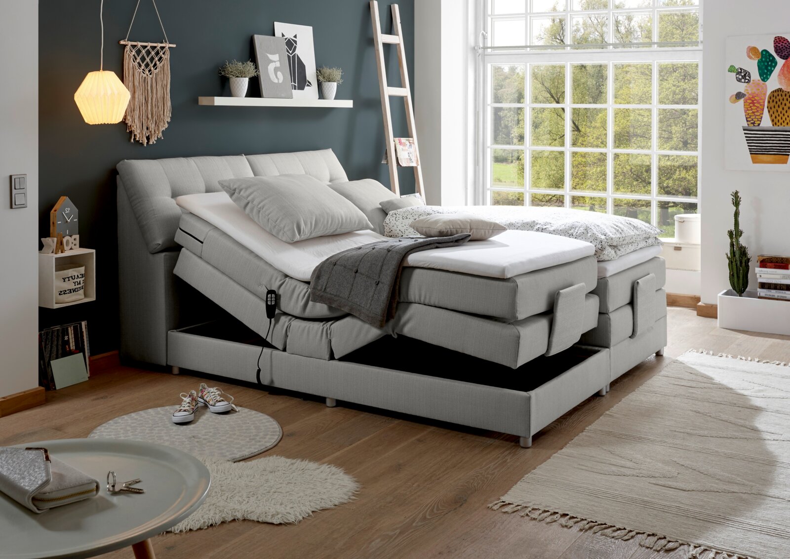 Modernes Boxspringbett mit verstellbaren Matratzen in einem hellen Schlafzimmer, seitliche Perspektive