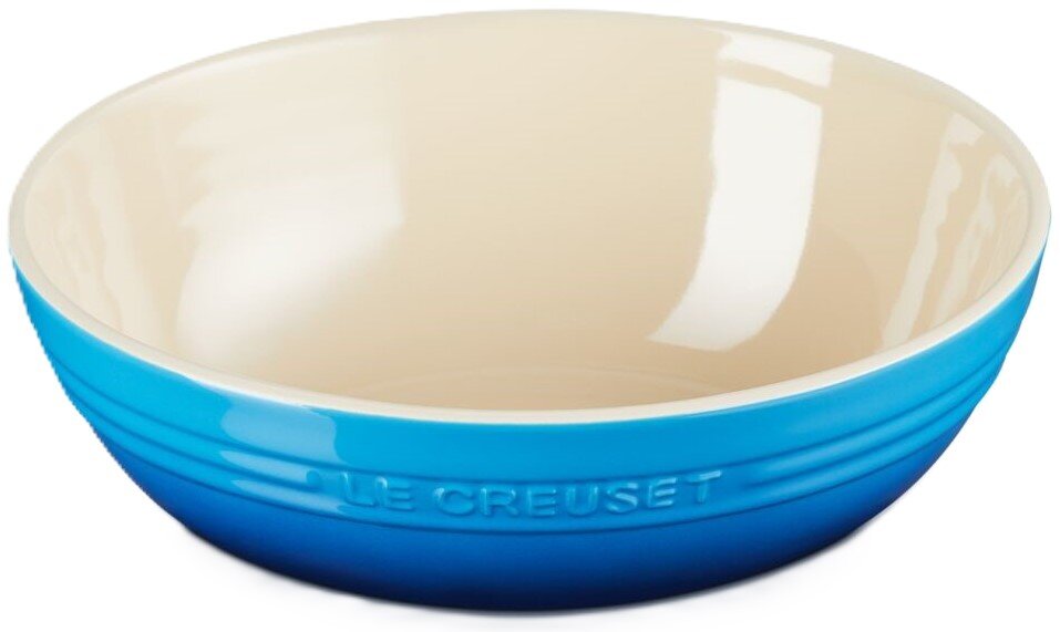 LE CREUSET Servierschale Blaue Keramikschüssel mit cremefarbener Innenseite und geprägtem Le Creuset Schriftzug, Produktansicht leicht von vorne/seitlich vor weißem Hintergrund