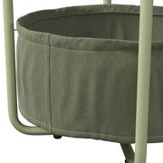 Nahaufnahme eines grünen Beistelltisches mit Stoffkorb und Metallgestell, seitliche Perspektive