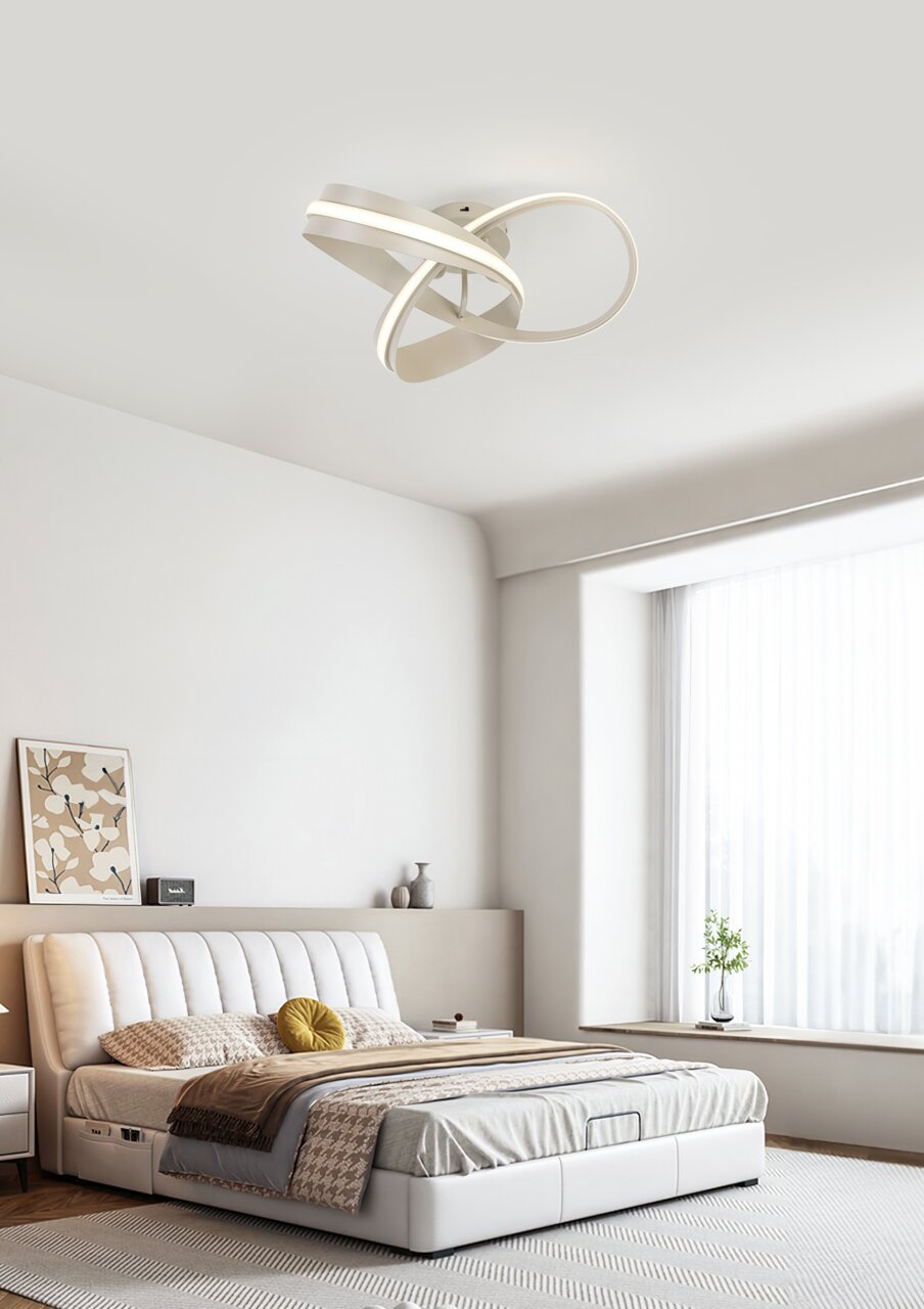 Moderne led-plafondlamp met een gebogen vorm, gezien van onderaf, gemonteerd in een stijlvolle slaapkamer.