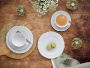Kaffeeservice 18-tlg aus der Vogelperspektive auf einem Holztisch arrangiert, mit Tassen, Untertassen, Tellern und goldenen Löffeln, umgeben von Blumen und Gebäck.
