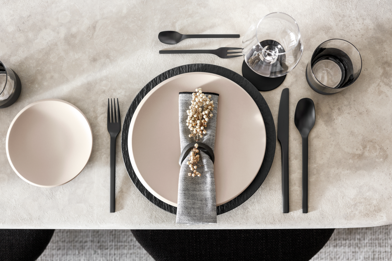 Villeroy & Boch Besteck 20-tlg. Manufacture Rock Cutlery Elegantes Besteckset in Schwarz, bestehend aus Messer, Gabel und Löffel, auf einem gedeckten Tisch mit Tellern und Gläsern, aus der Vogelperspektive fotografiert.