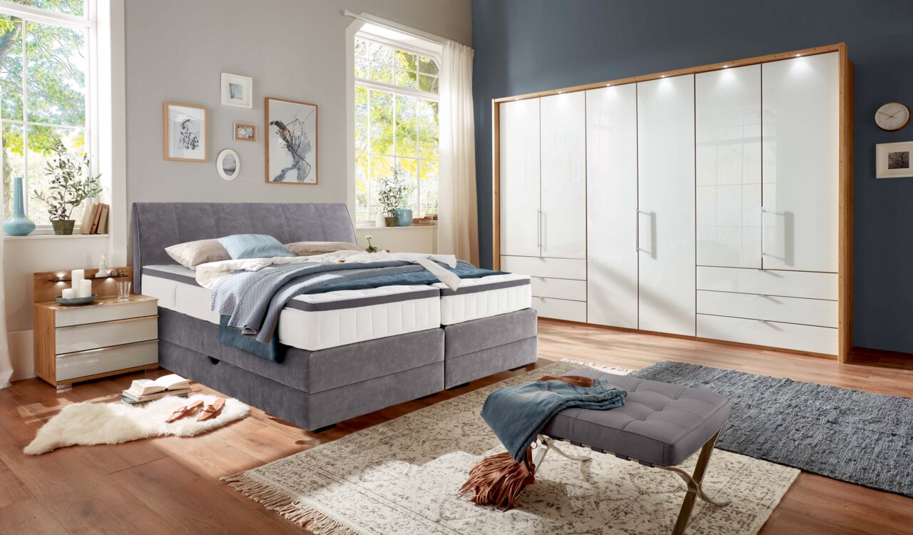 Gemütliches Boxspringbett in einem modernen Schlafzimmer, seitliche Perspektive