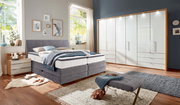 Gemütliches Boxspringbett in einem modernen Schlafzimmer, seitliche Perspektive