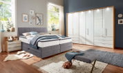 Gemütliches Boxspringbett in einem modernen Schlafzimmer, seitliche Perspektive