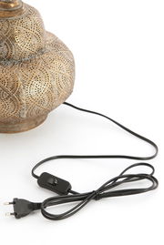 Nahaufnahme eines kunstvoll verzierten Lampenfußes mit orientalischem Muster, seitliche Perspektive, mit schwarzem Kabel und Schalter.