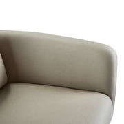 Nahaufnahme eines beigen Armlehnstuhls aus seitlicher Perspektive