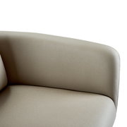 Nahaufnahme eines beigen Armlehnstuhls aus seitlicher Perspektive