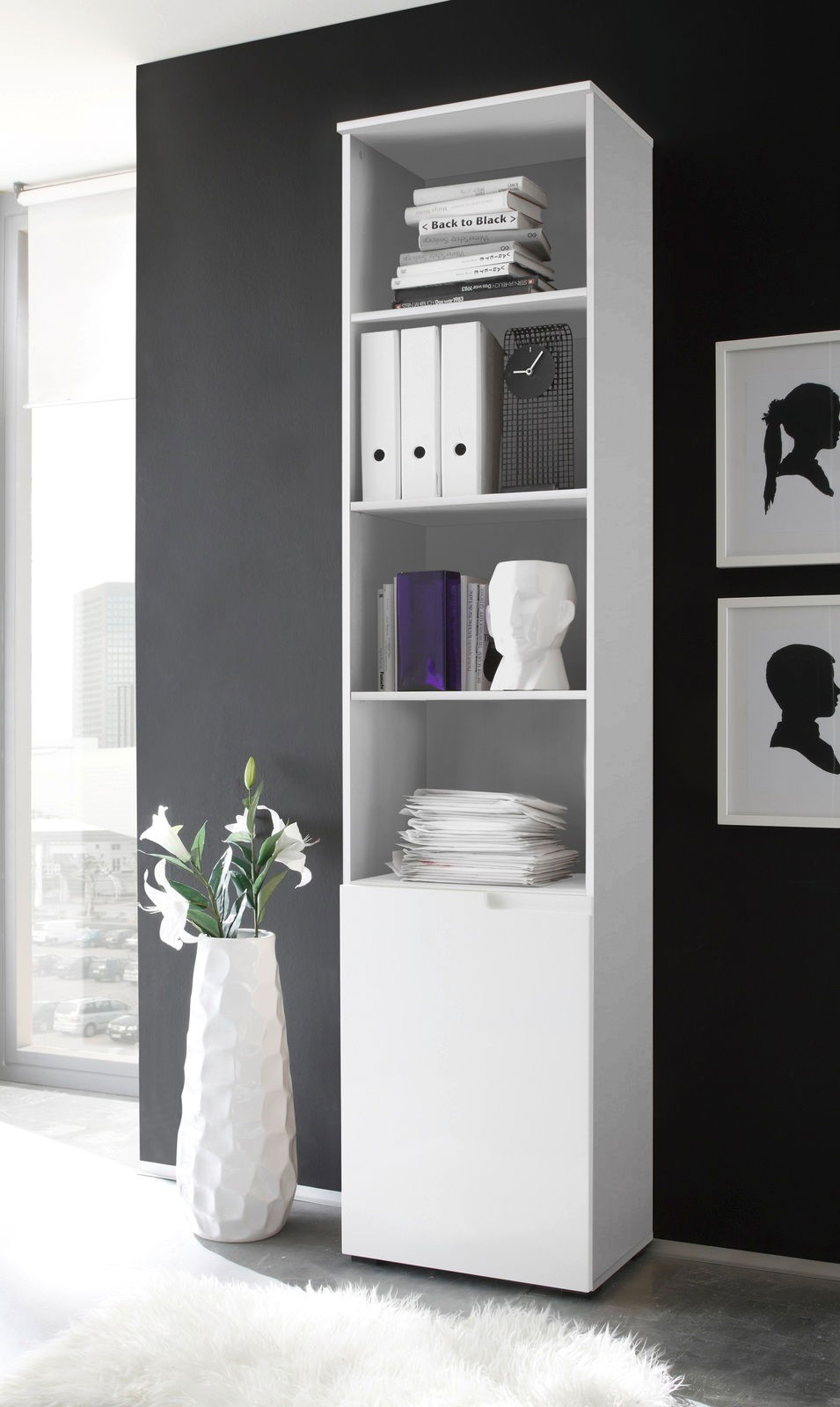 Weißes hohes Regal mit mehreren Fächern, gefüllt mit Büchern, Ordnern und Dekorationen, seitliche Perspektive.